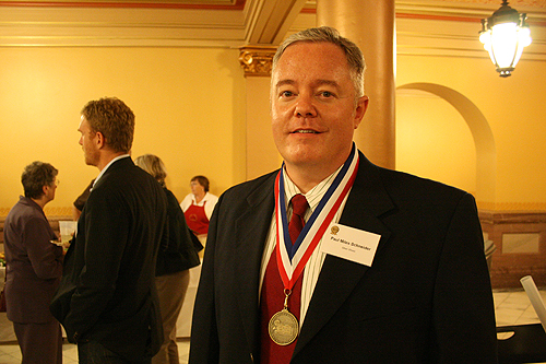 Paul Miles Schneider proudly wears his medal for “Silver Shoes” at the 2010 Kansas Notable Books awards reception.