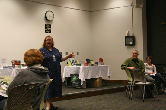 Maria Butler, the Community Relations Coordinator of the Lawrence Public Library, introduces the event and gives a few announcements about the proceedings while author Paul Miles Schneider looks on.