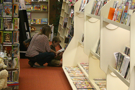 Lori Herbel Grimmett and her son, an avid eight-year-old reader, search for a new book together at Town Crier Bookstore in Emporia, Kansas.