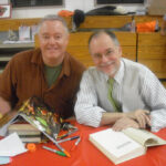 Paul Miles Schneider sits with Gregory Maguire while he signs Paul's first edition of "Wicked: The Life and Times of the Wicked Witch of the West." This photo was taken at Chittenango High School, during our first book-signing on Friday night.