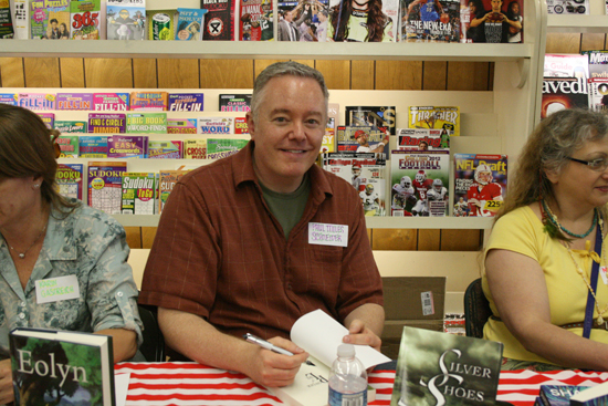 Paul Miles Schneider signs a copy of "The Powder of Life," the sequel to his novel "Silver Shoes," at the Town Crier Bookstore in Emporia, Kansas.